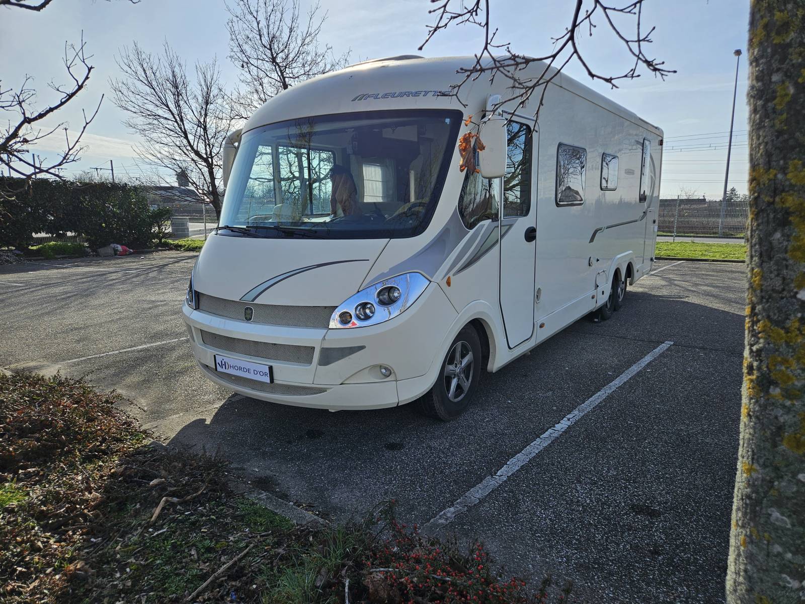 Vue de trois-quart avant gauche. On distingue le design élégant de la face avant intégrale et le logo Fleurette au-dessus du pare-brise.